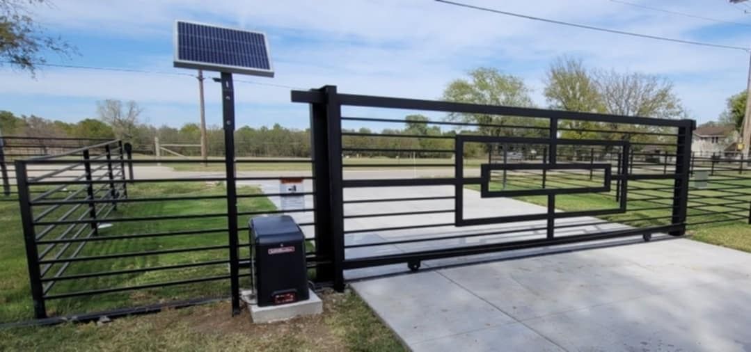 A black gate with a solar panel on top of it.