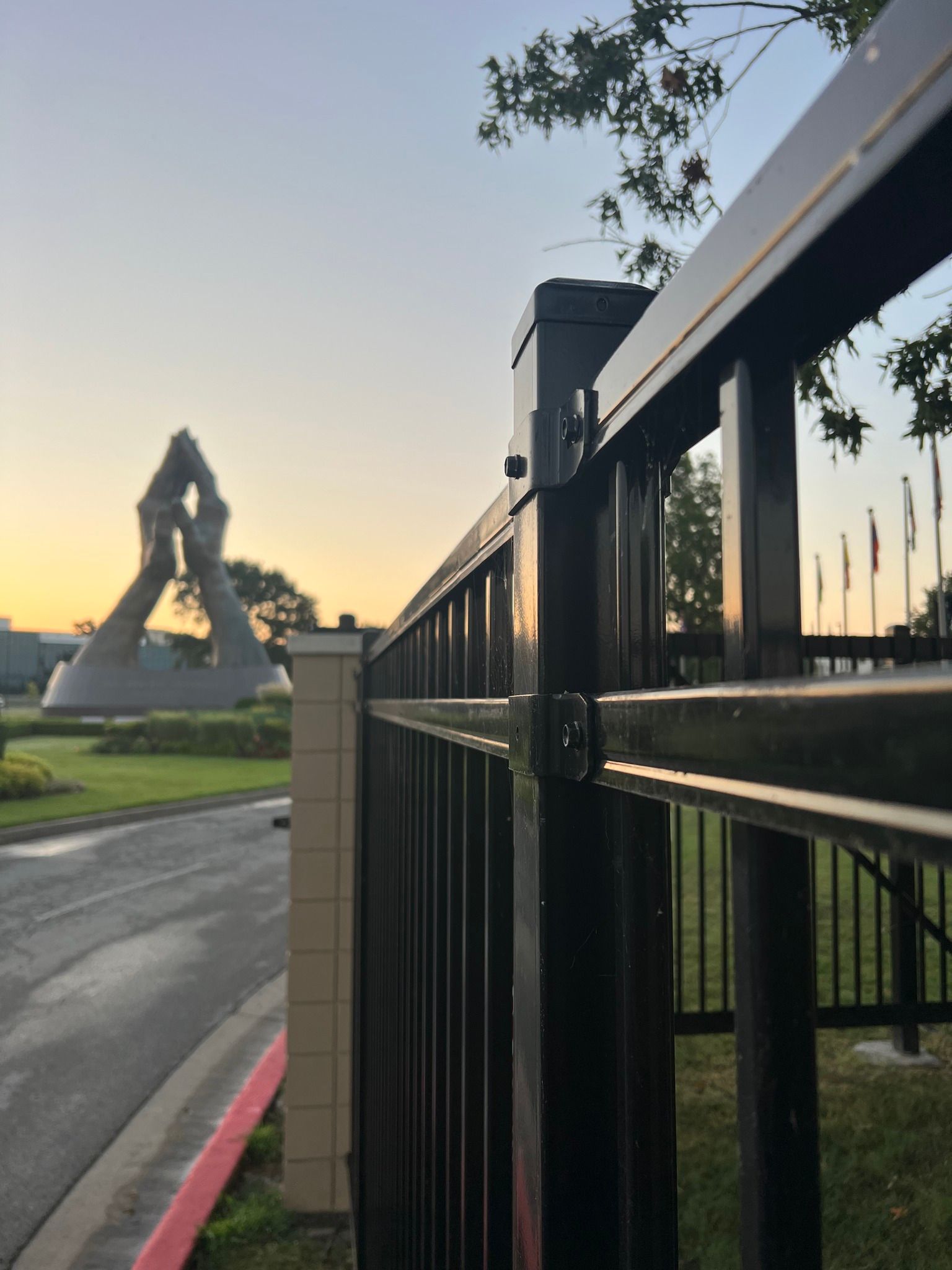 A black fence with a statue in the background