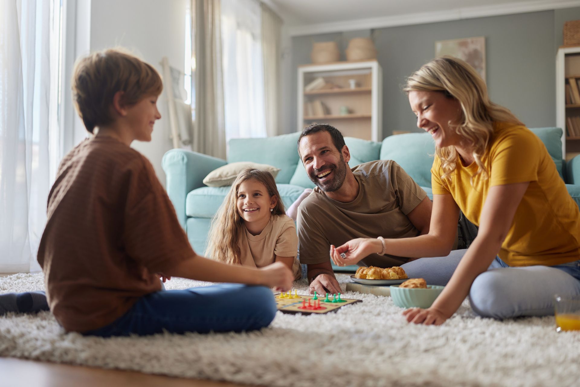 A man is using a vacuum cleaner to clean a carpet in a living room.