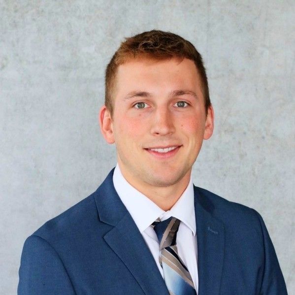 A man in a suit and tie is smiling for the camera