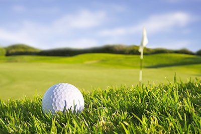 A golf ball is sitting in the grass on a golf course.