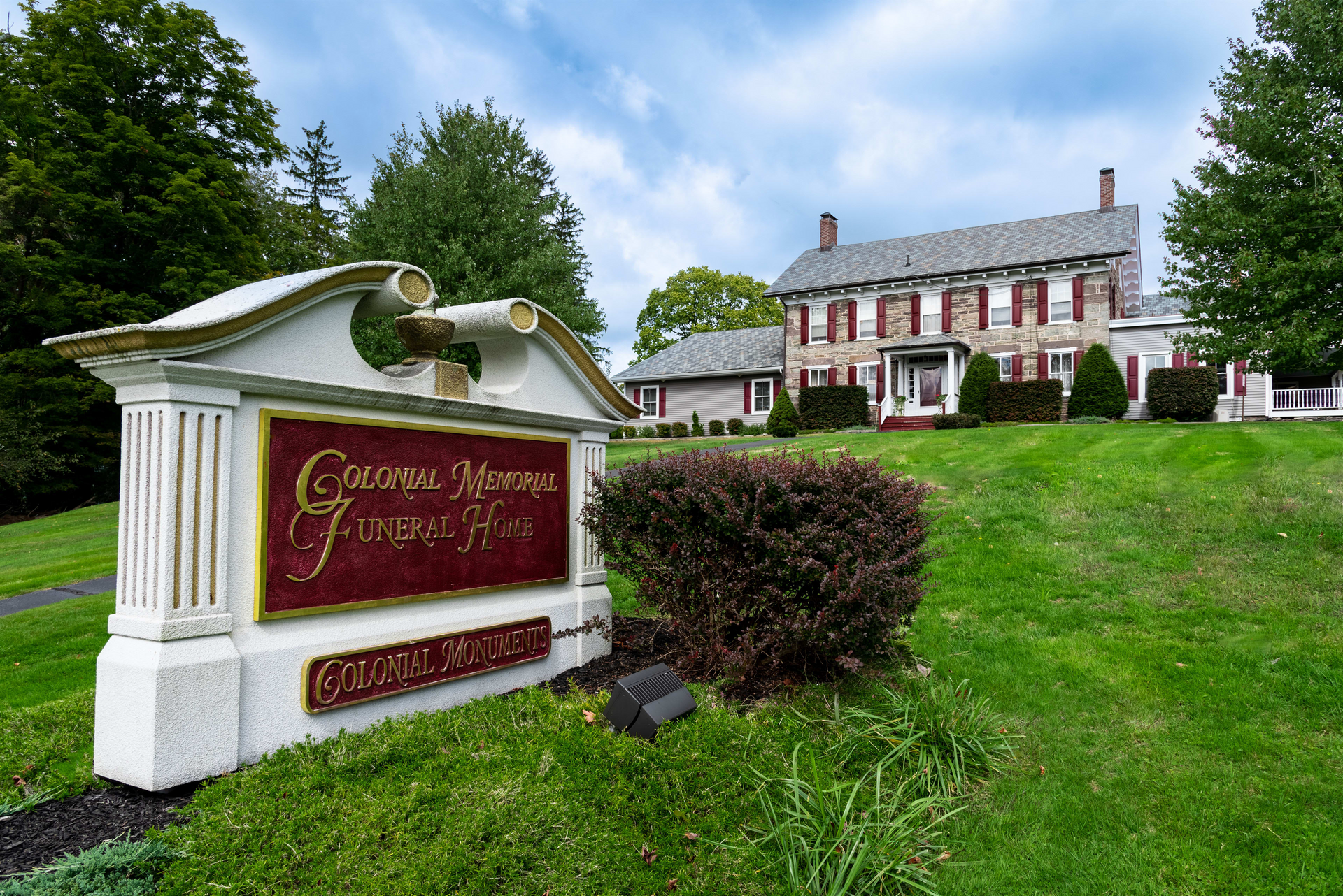A large house with a sign in front of it that says george moore funeral home