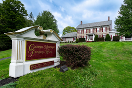 A large house with a sign in front of it that says george moore funeral home