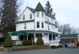 A large white house with a green roof