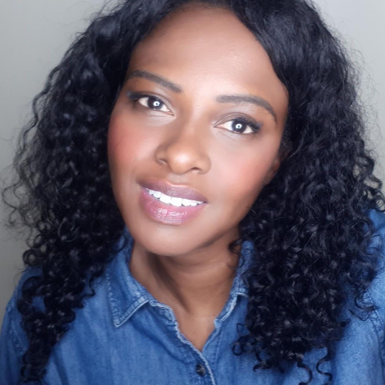 A woman with curly hair is wearing a blue shirt