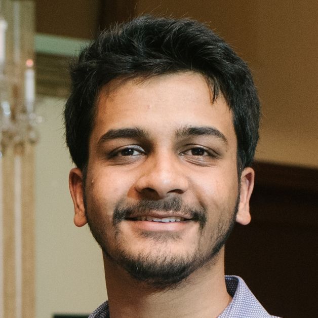 A young man with a beard is smiling for the camera.