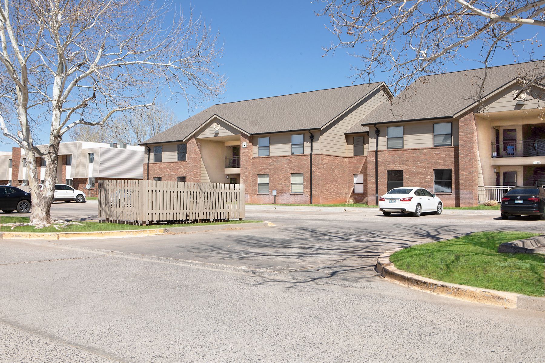 a white car is parked in front of a brick apartment building