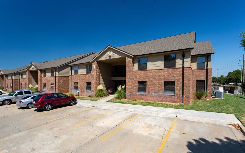 a red suv is parked in front of a brick apartment building