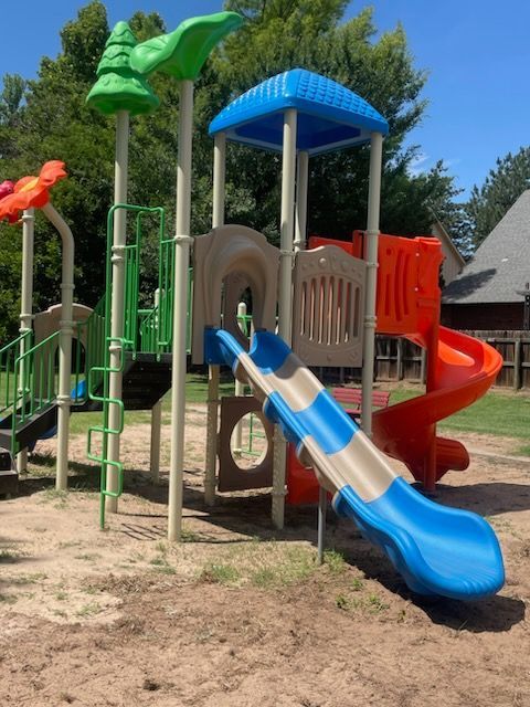 a playground with a blue slide and a red slide