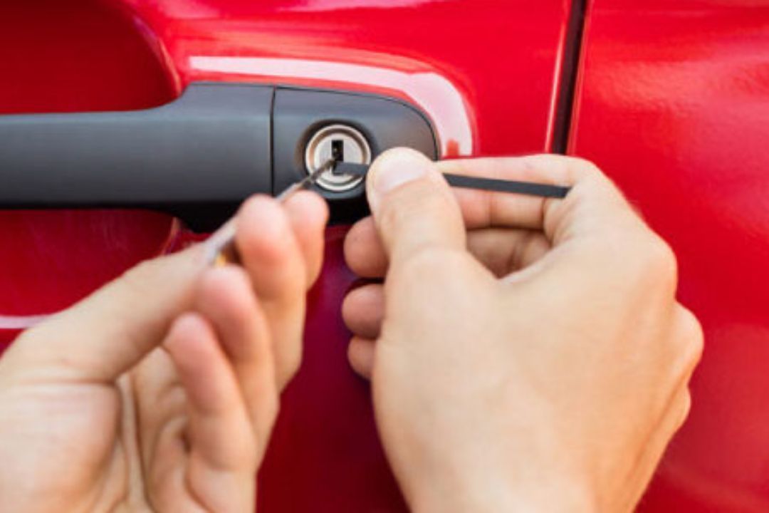 A person is opening a car door with a screwdriver.