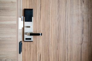 A wooden door with a digital door lock on it.