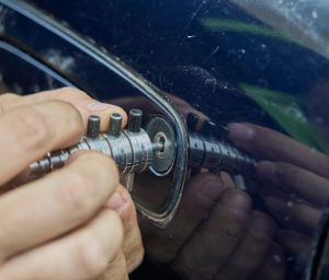 A person is using a key to open a car door.