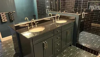 A bathroom with two sinks and a walk in shower.