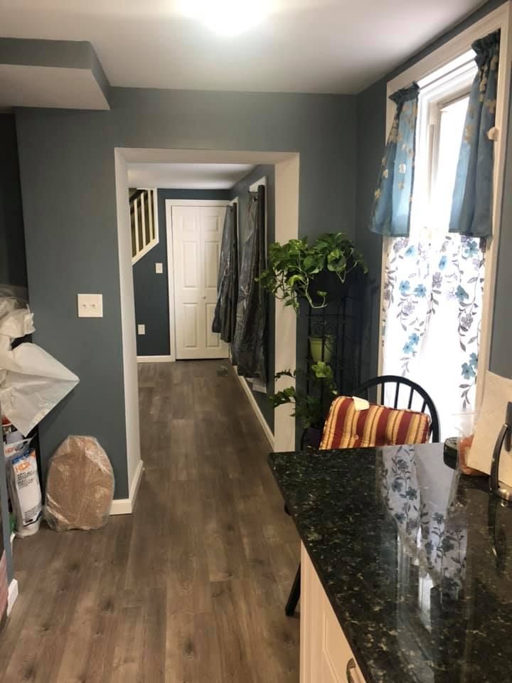 A kitchen with hardwood floors and a black counter top.