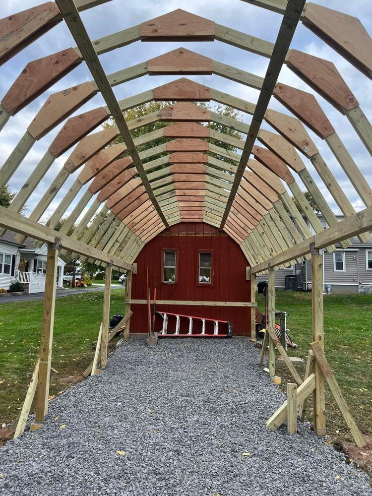 A wooden structure is being built around a red barn.