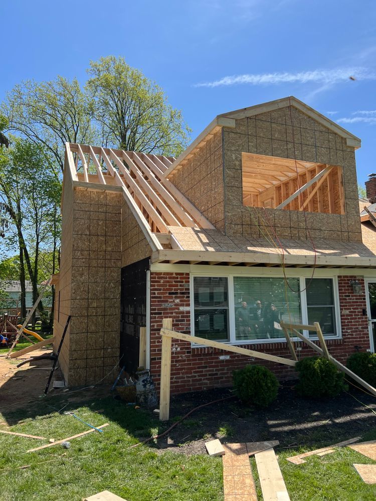 A brick house is being remodeled with a wooden roof.