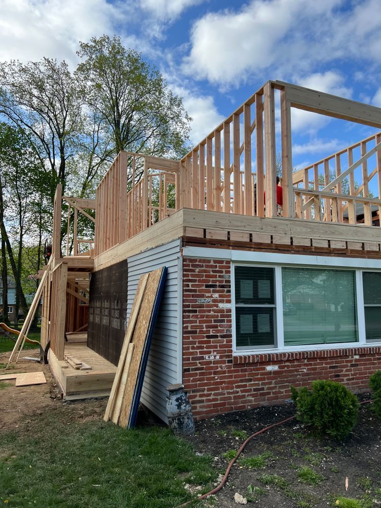 A brick house is being remodeled with a wooden deck.
