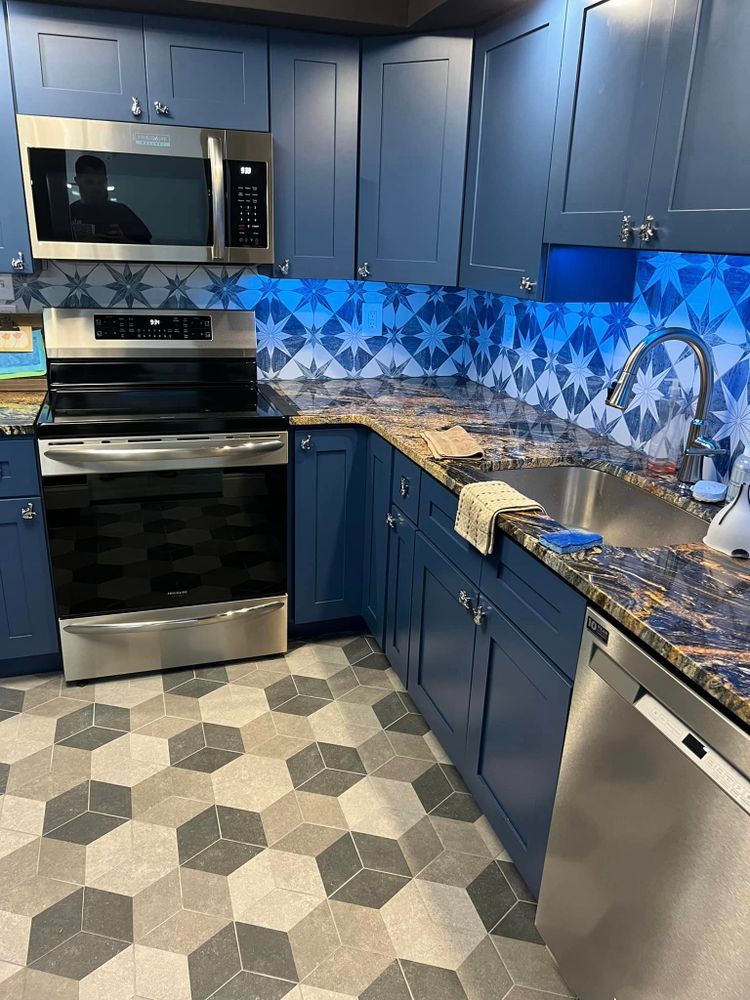 A kitchen with blue cabinets and stainless steel appliances