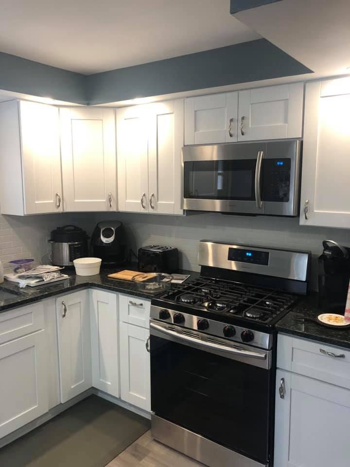 A kitchen with white cabinets and stainless steel appliances.