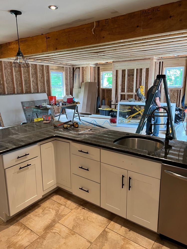 A kitchen under construction with a sink and a ladder.