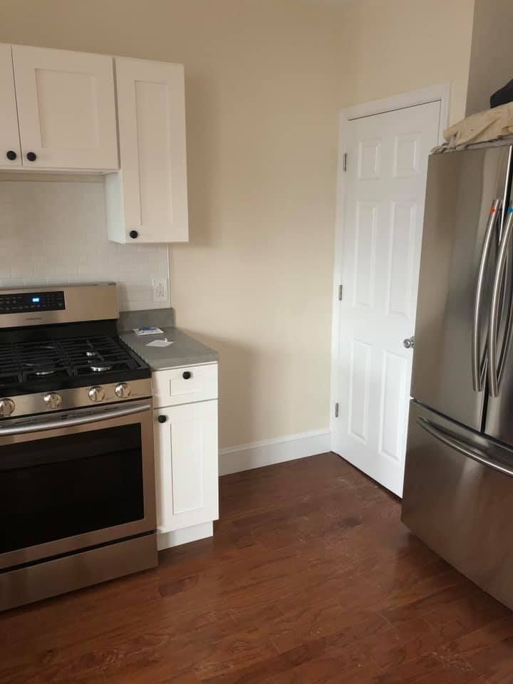 A kitchen with a stove , refrigerator , and cabinets.