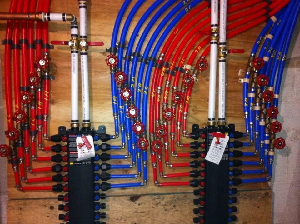 A wall filled with red and blue pipes and valves