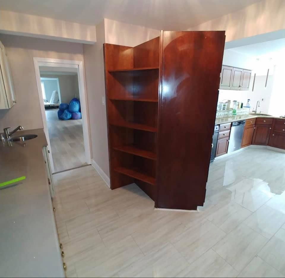 A kitchen with a large wooden shelf in the corner