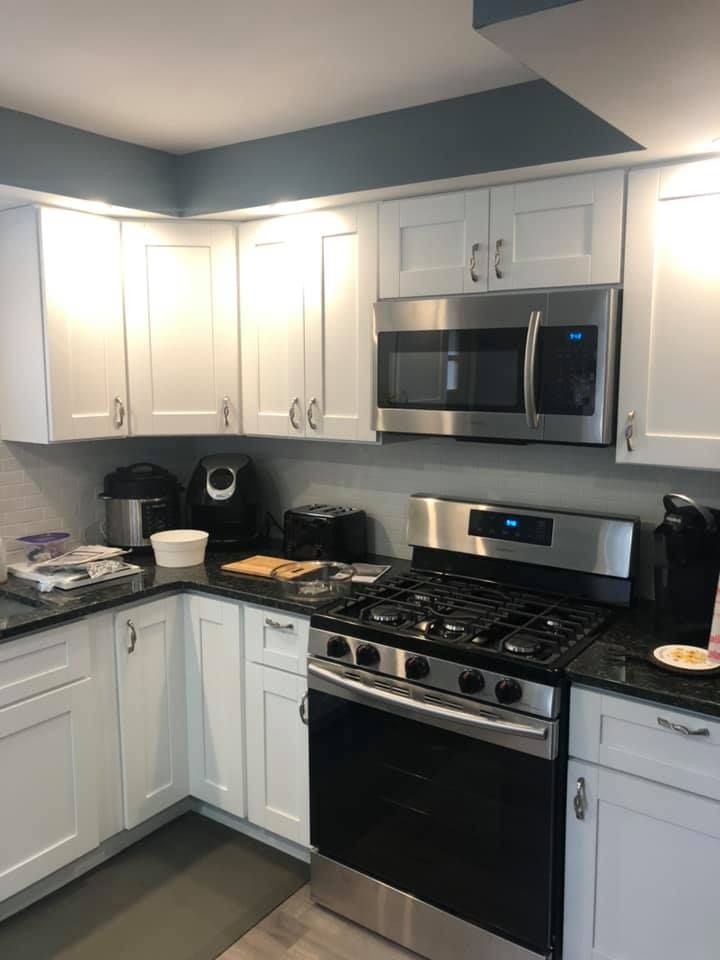 A kitchen with white cabinets and stainless steel appliances.