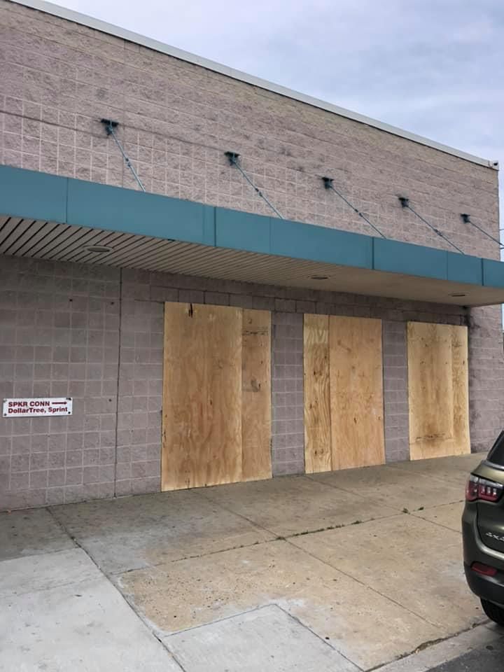 A brick building with wooden doors and a car parked in front of it.