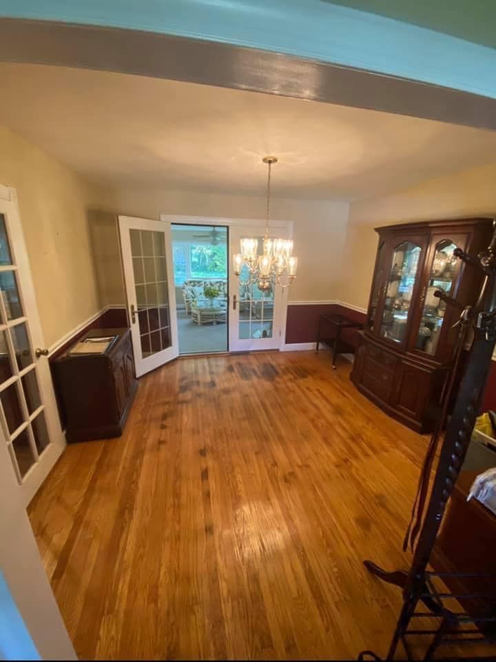 A dining room with hardwood floors and a chandelier.