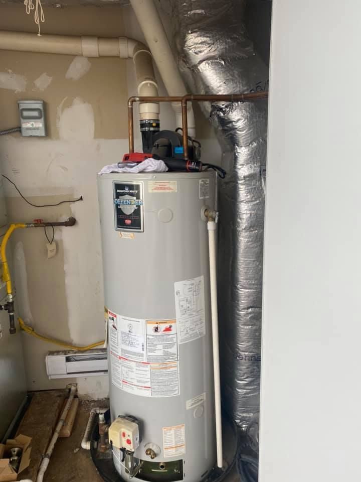 A water heater is sitting in a room next to a wall.