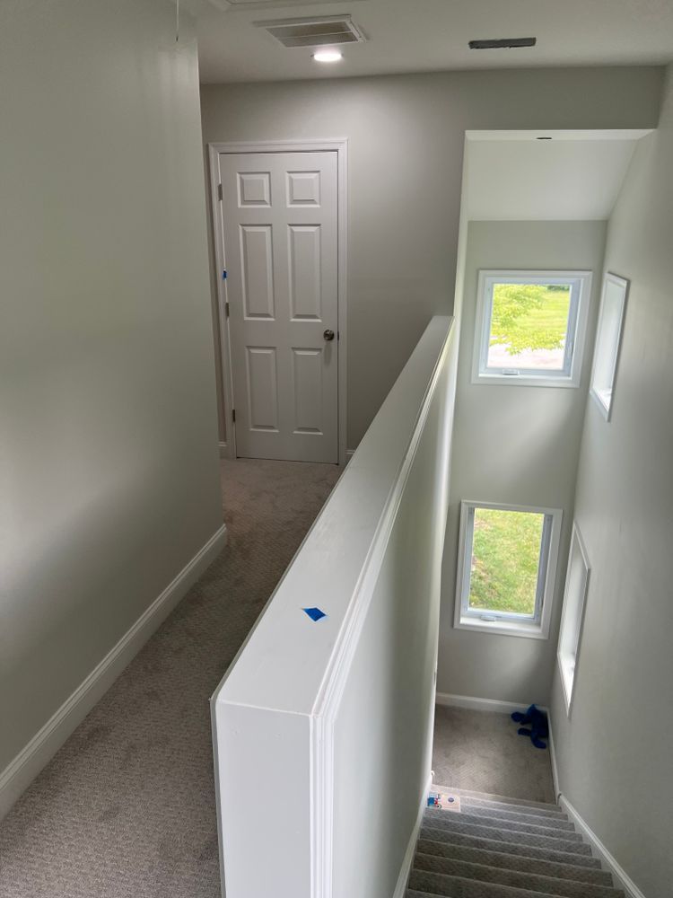 A hallway with stairs leading up to the second floor of a house.