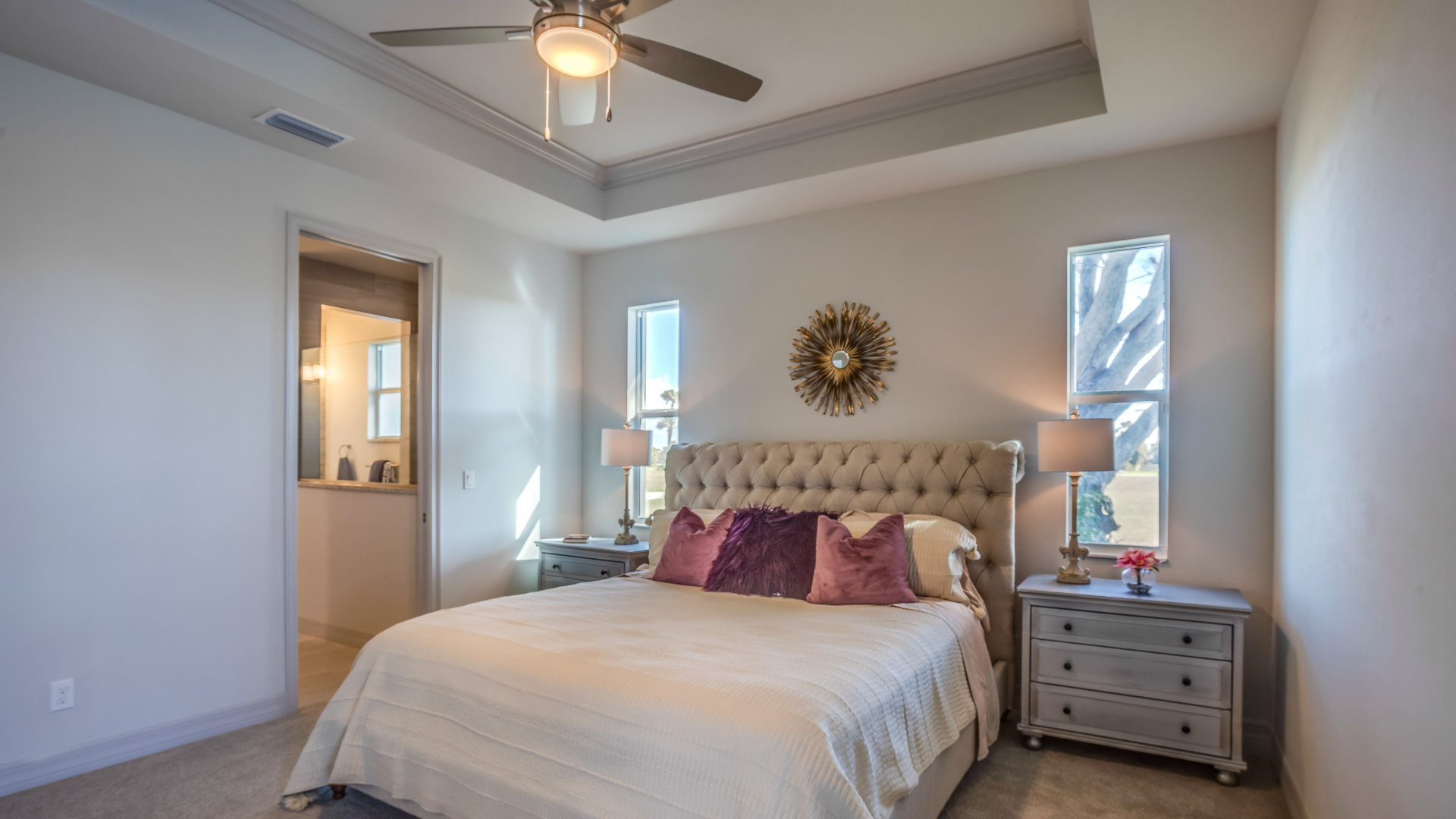 A bedroom with a large bed and a ceiling fan.