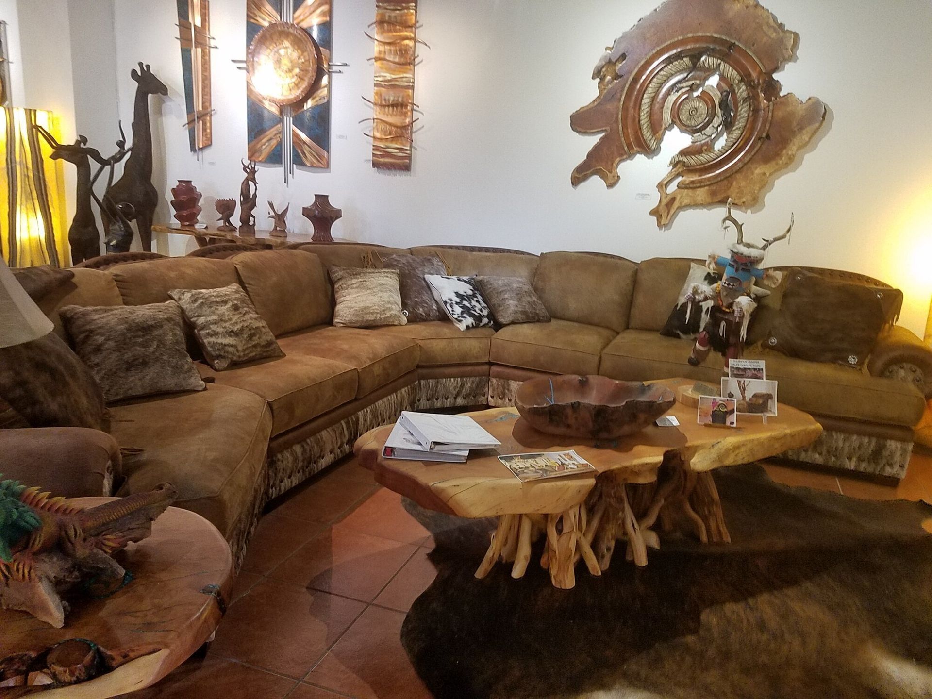 A hand-painted ceramic vase with spiral designs sits on a rustic wooden stand in a shop window overlooking a street.