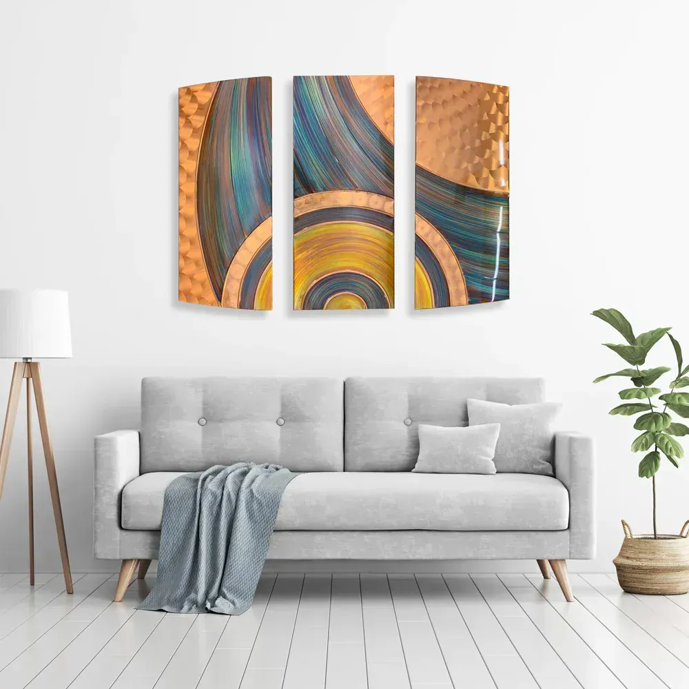 A living room features a grey couch, a tripod floor lamp, and a plant, with a three-panel abstract metal wall art piece.