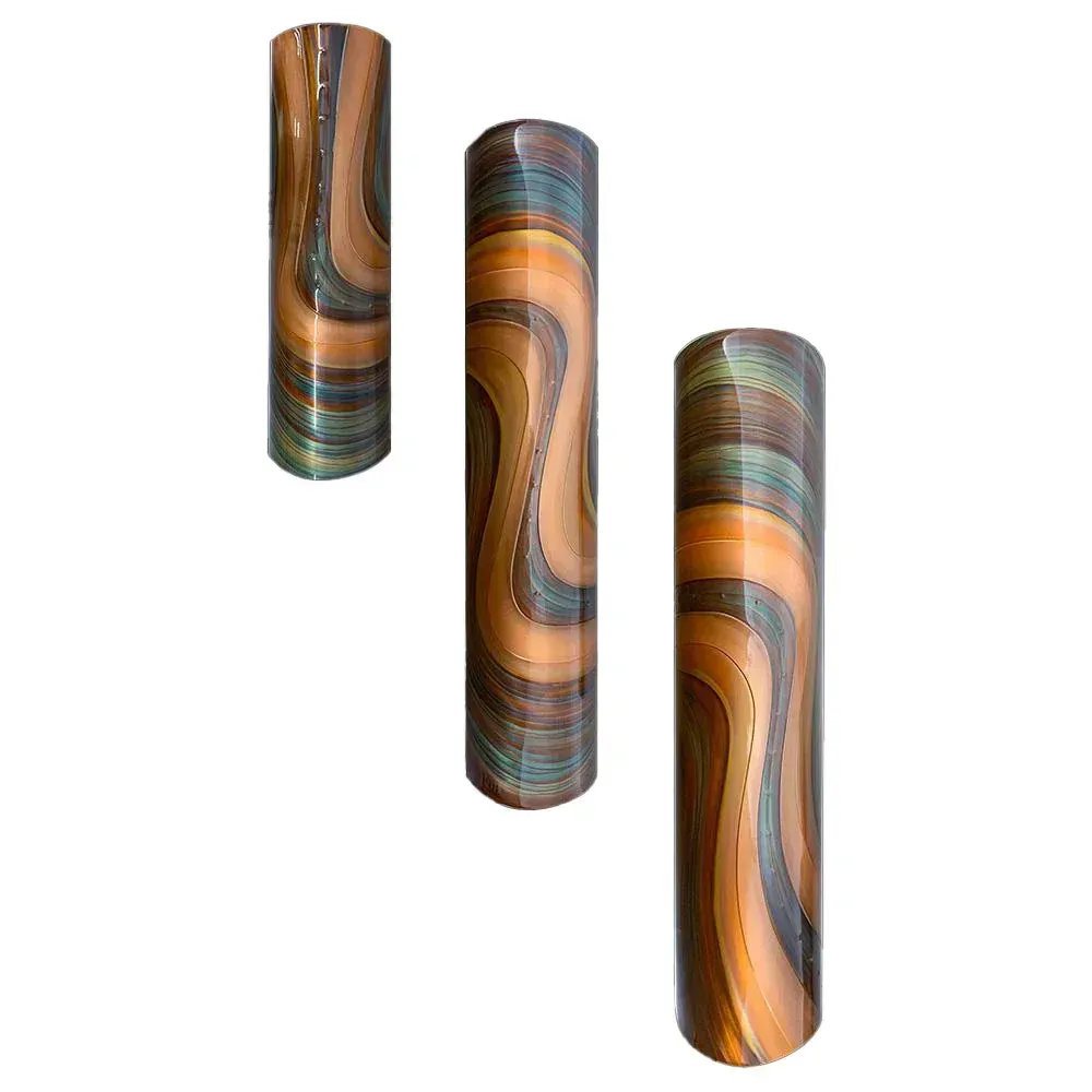 Three cylindrical wall art pieces with an abstract wavy pattern in shades of orange, brown, and turquoise.