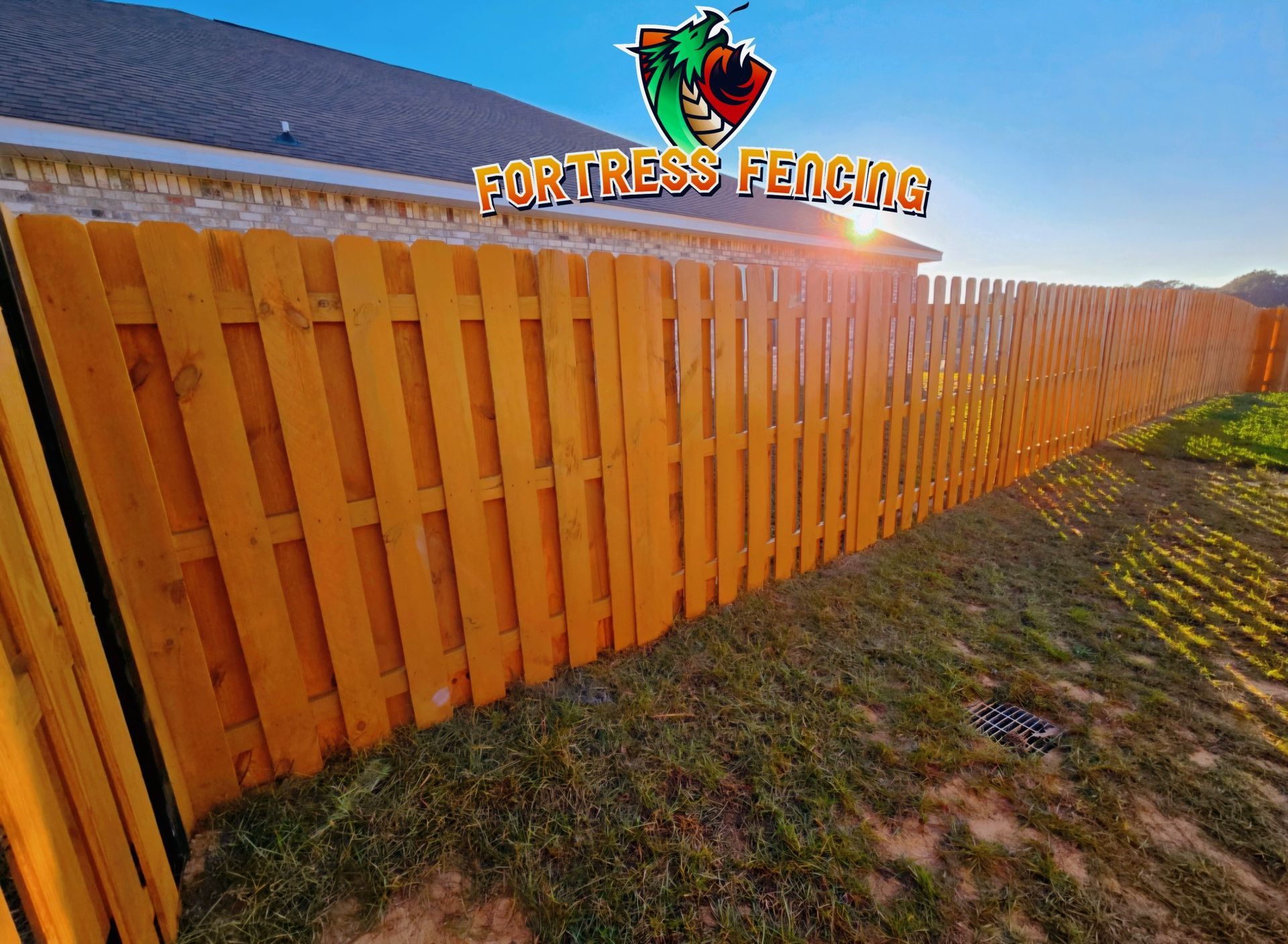 Wooden fence with sun shining through, logo 