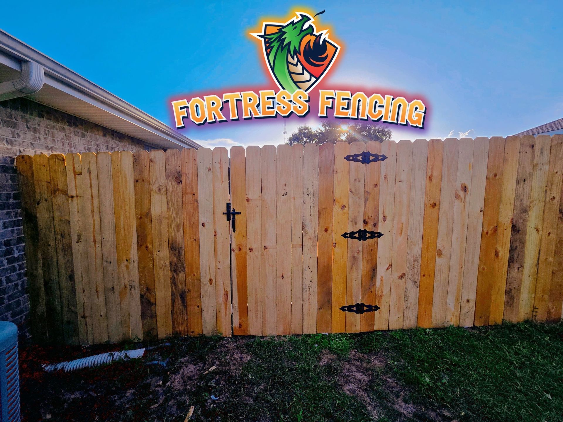 Wooden fence with gate, Fortress Fencing logo above.