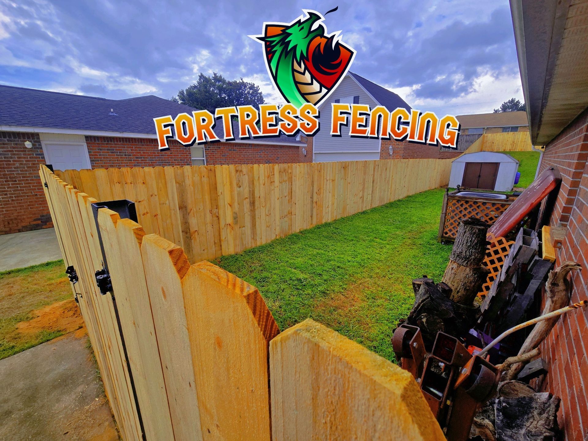 A wooden fence in a backyard; logo reads