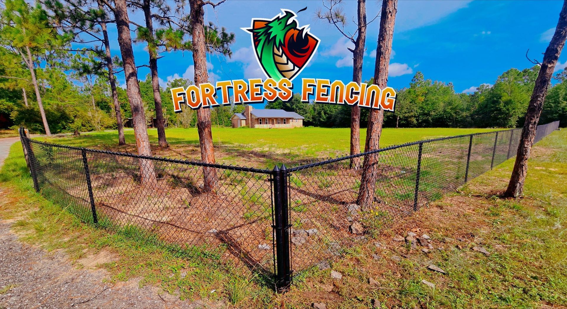 Black chain-link fence around green yard with trees. Fortress Fencing logo on banner.