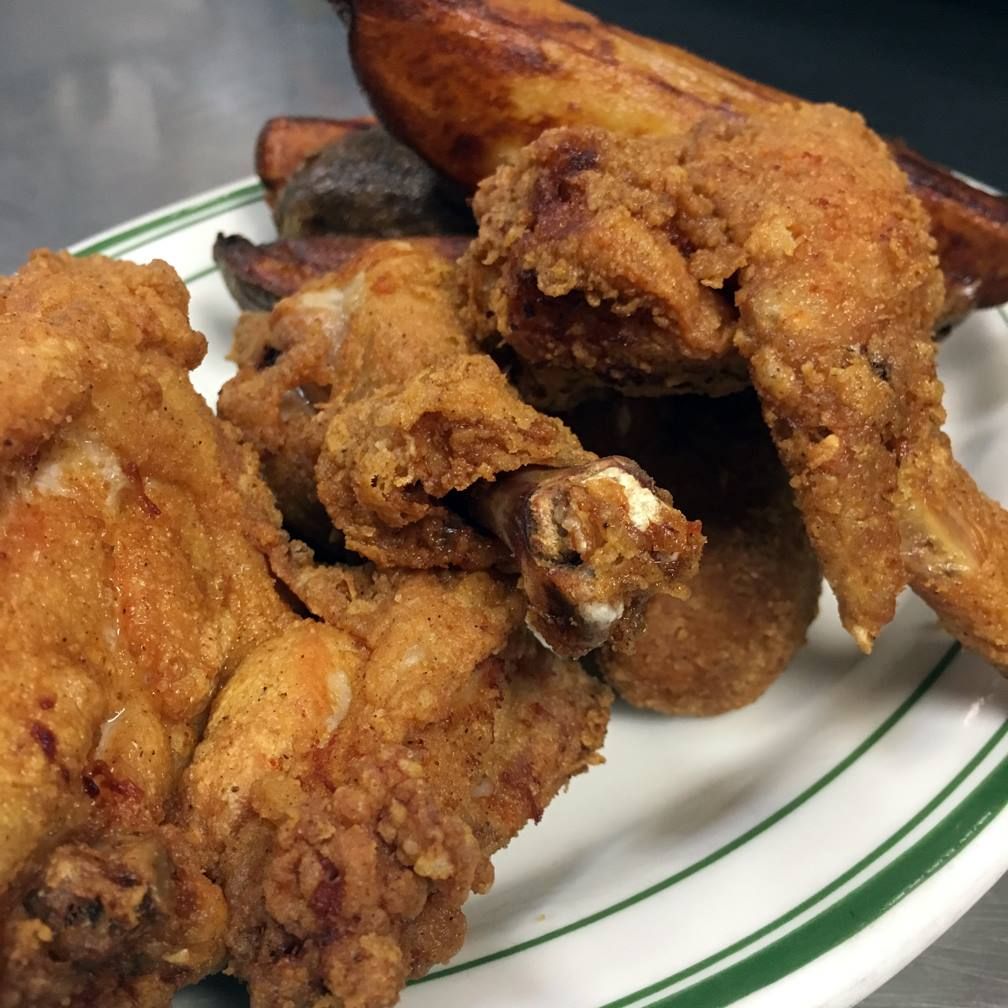 Fried chicken and potatoes on a plate with green trim.