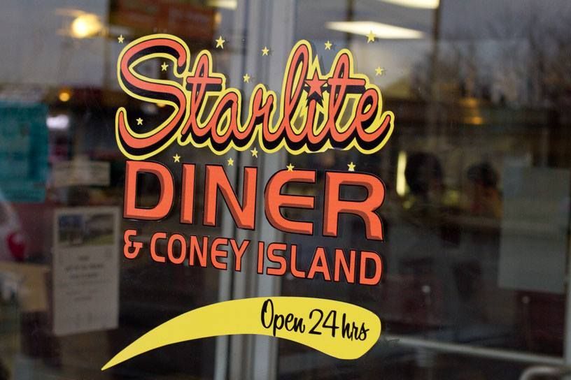 Starlite Diner & Coney Island sign on glass door. Orange and yellow text,