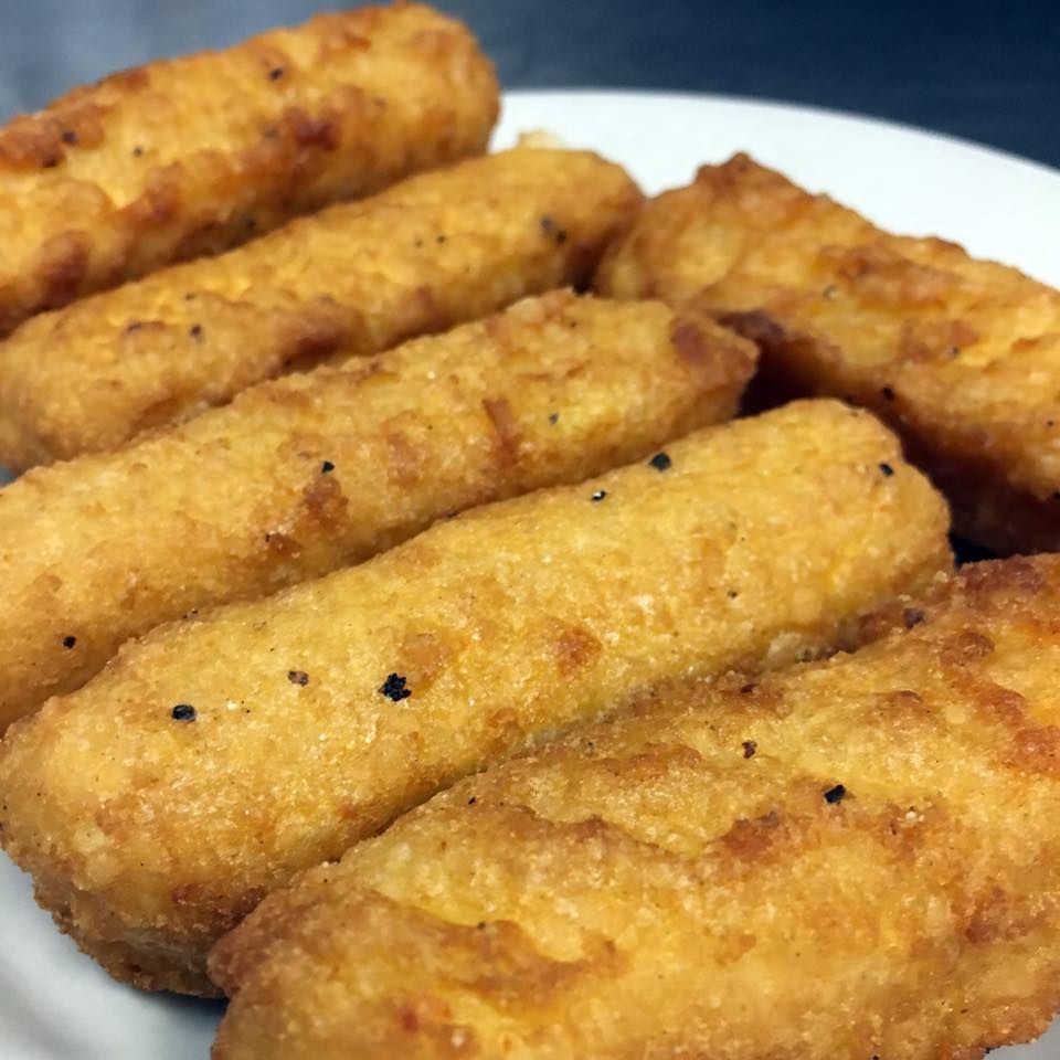 Golden, fried cheese sticks on a white plate.