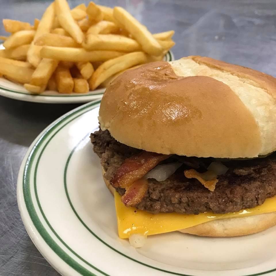 Burger with bacon and fries on a plate.