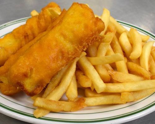 Fish and chips: Two pieces of battered fish and a pile of golden french fries on a white plate with green trim.
