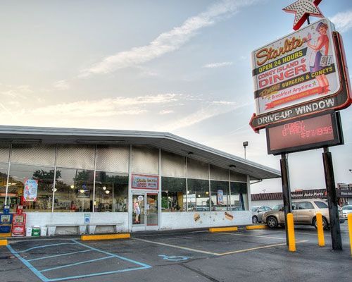 Starlite Diner with sign: a retro, white diner with large windows and a parking lot.