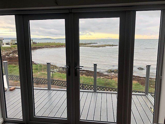 A view of the ocean from a balcony with sliding glass doors.