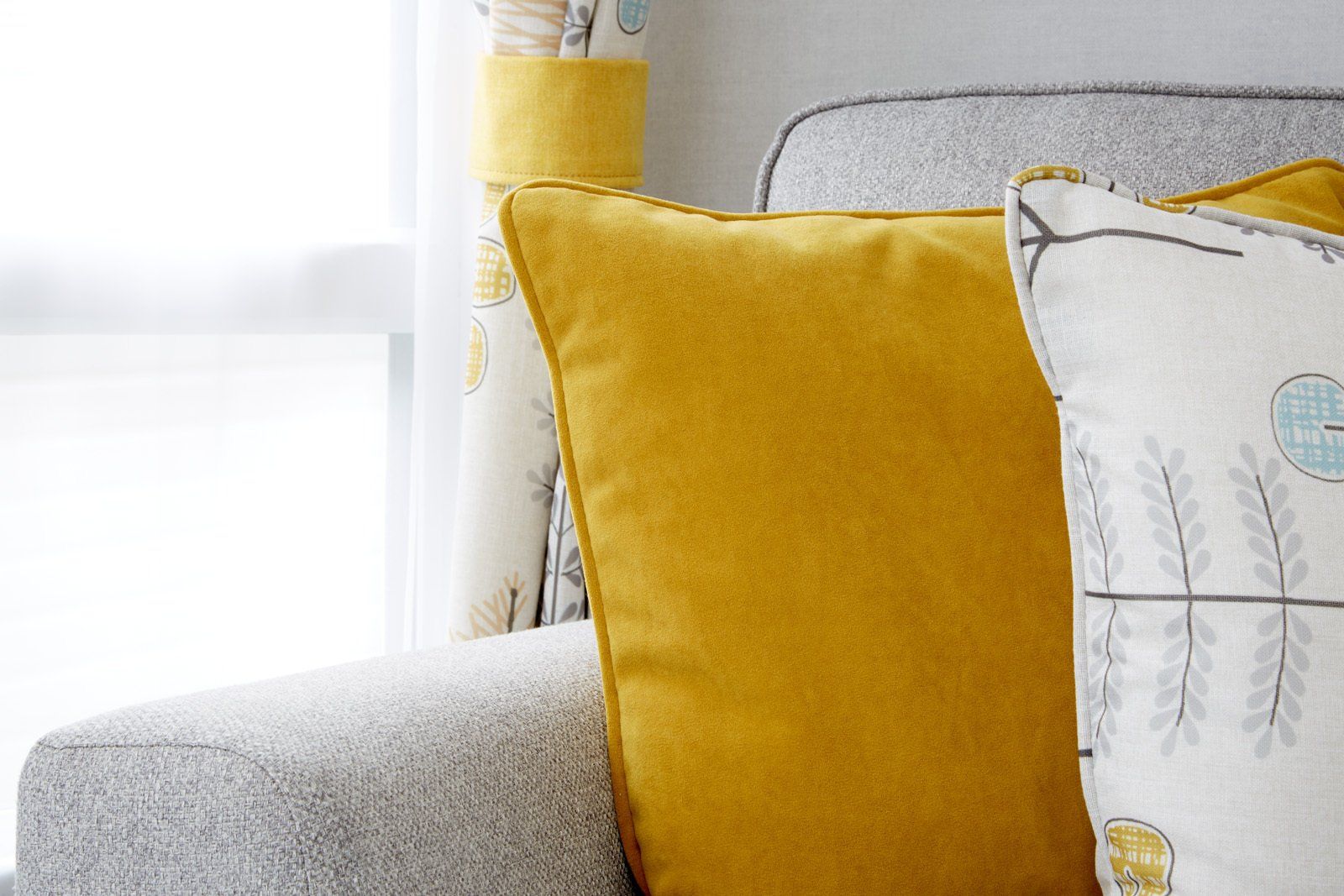 A couch with a yellow pillow and a white pillow on it.