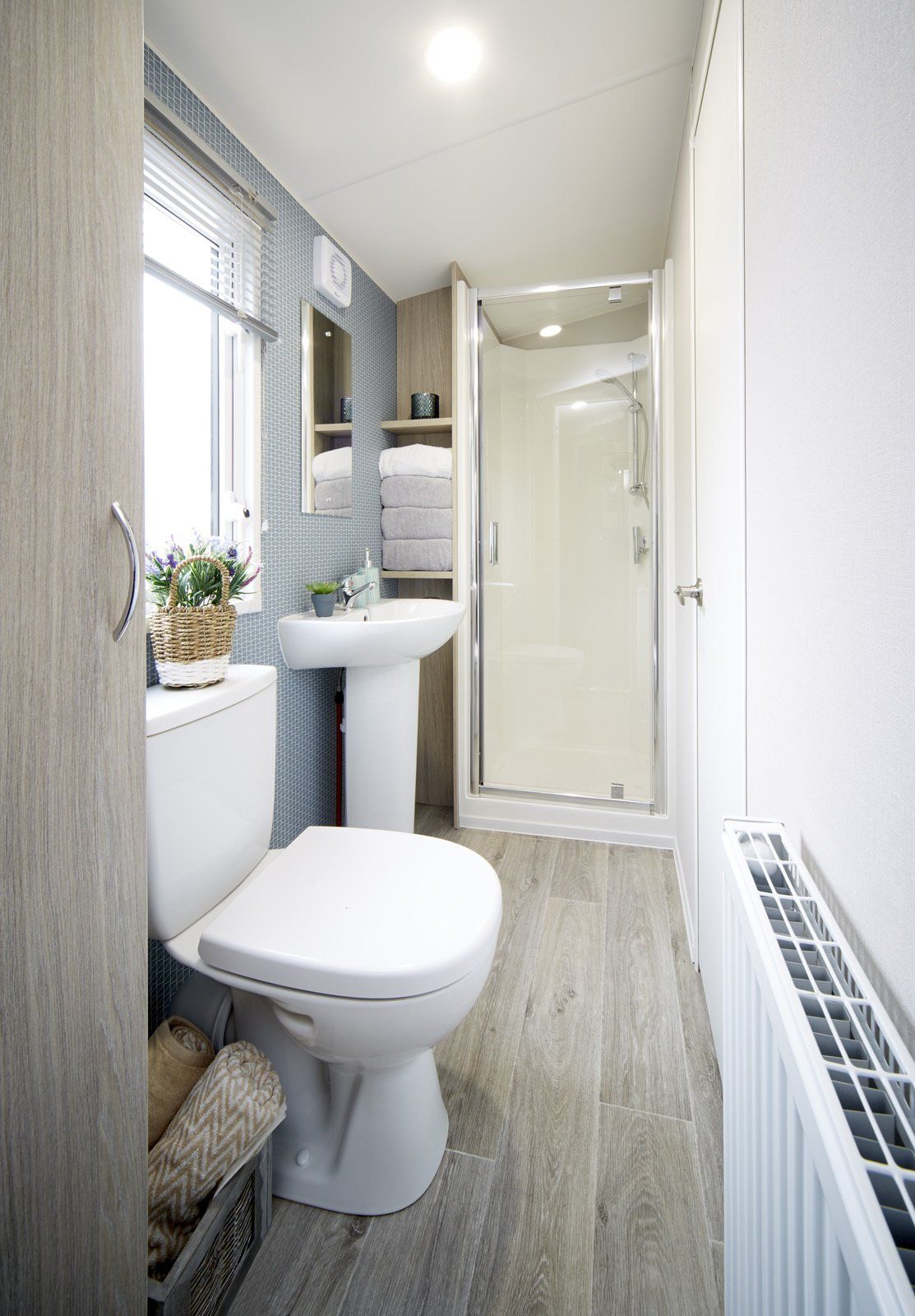 A bathroom with a toilet , sink and shower.