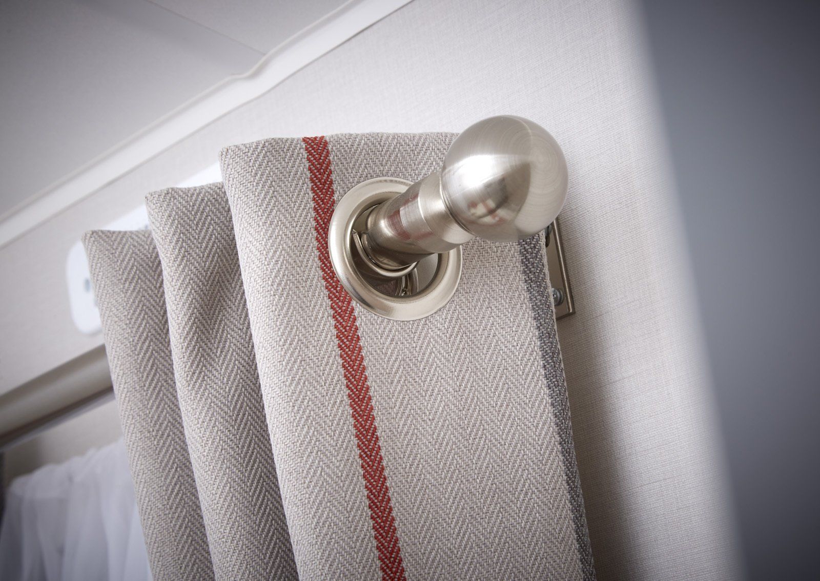 A close up of a curtain with a metal pole attached to it.